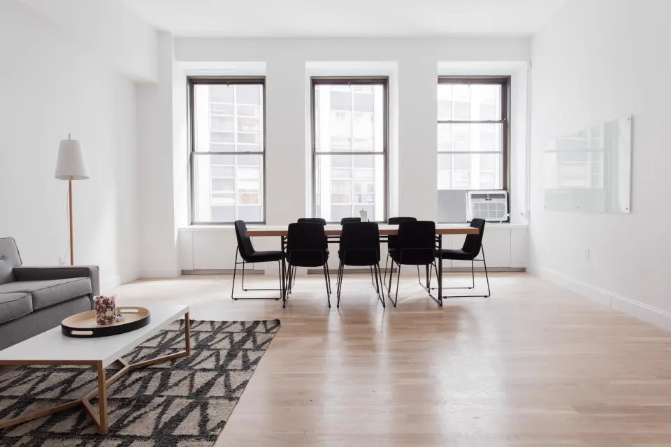 Apartment dining area with tall windows and area rug