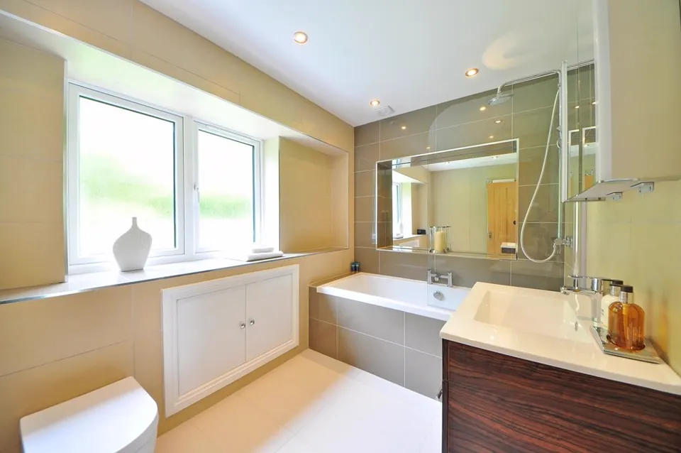 Bright bathroom with bathtub, vanity and large mirror