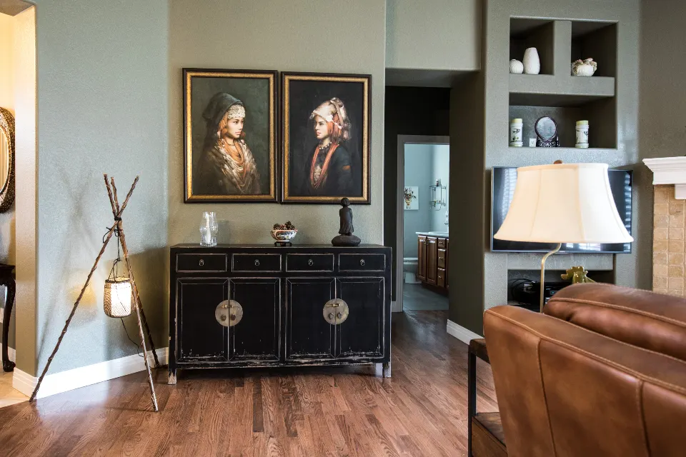 Classic living room with black sideboard, portraits and leather sofa