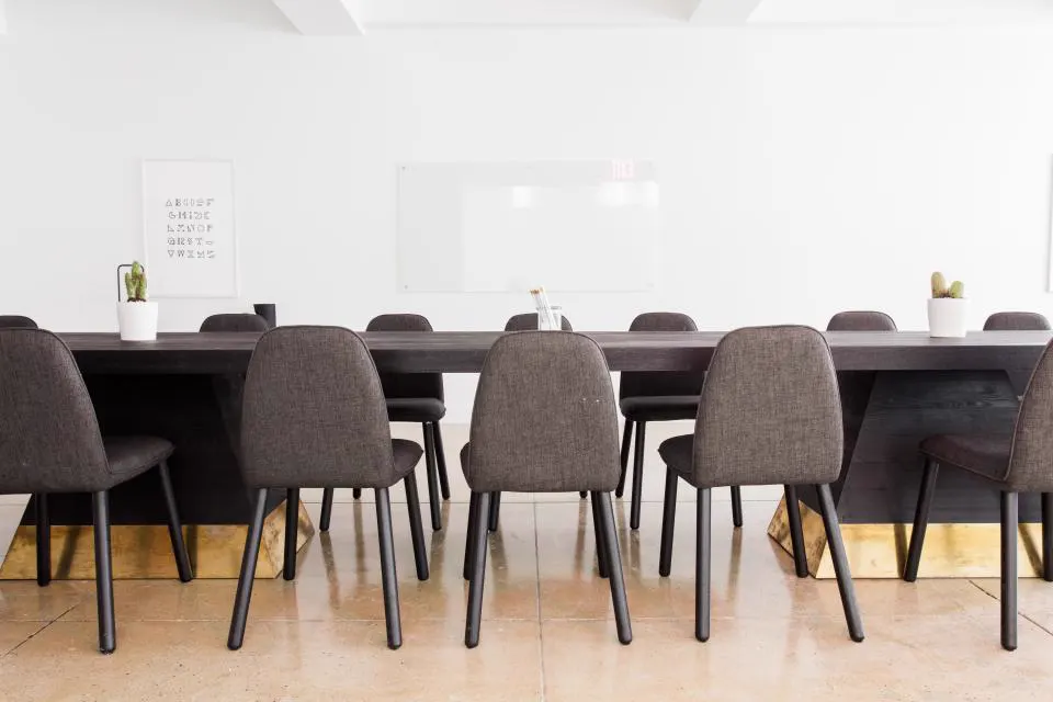 Modern conference room with long table and grey chairs