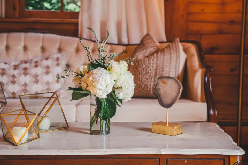 Home decor styling with flowers, brass accents and velvet sofa