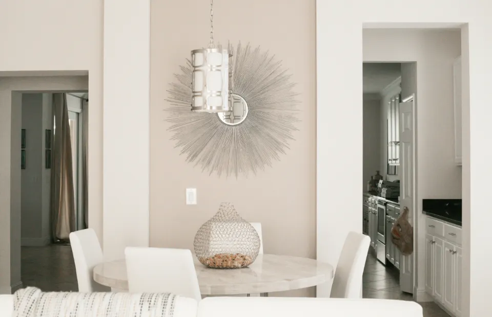Dining room with sunburst mirror and round table