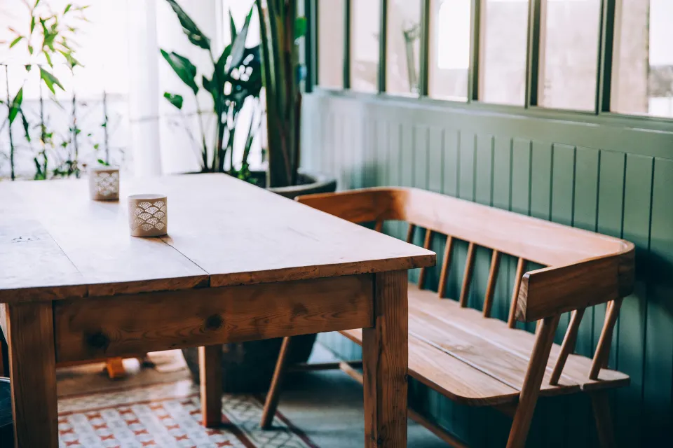 Dining nook with green wall panelling and wooden bench