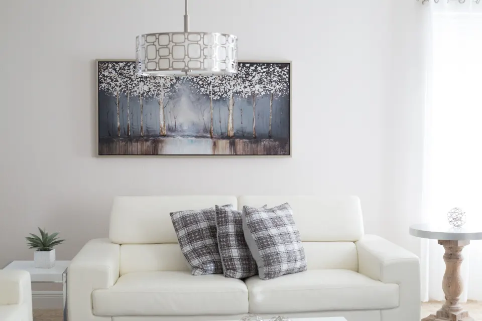 Elegant living room with white sofa, chandelier and wall art