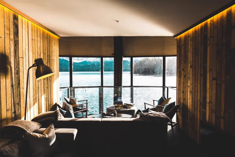 Wood panelled lounge with warm cove lighting and lake view