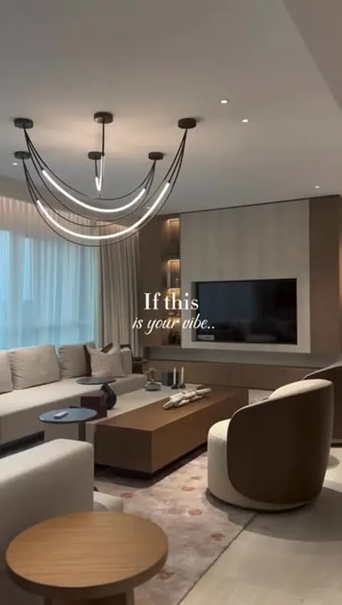 Luxury living room interior with sculptural chandelier and TV wall designed by Asaya Interiors